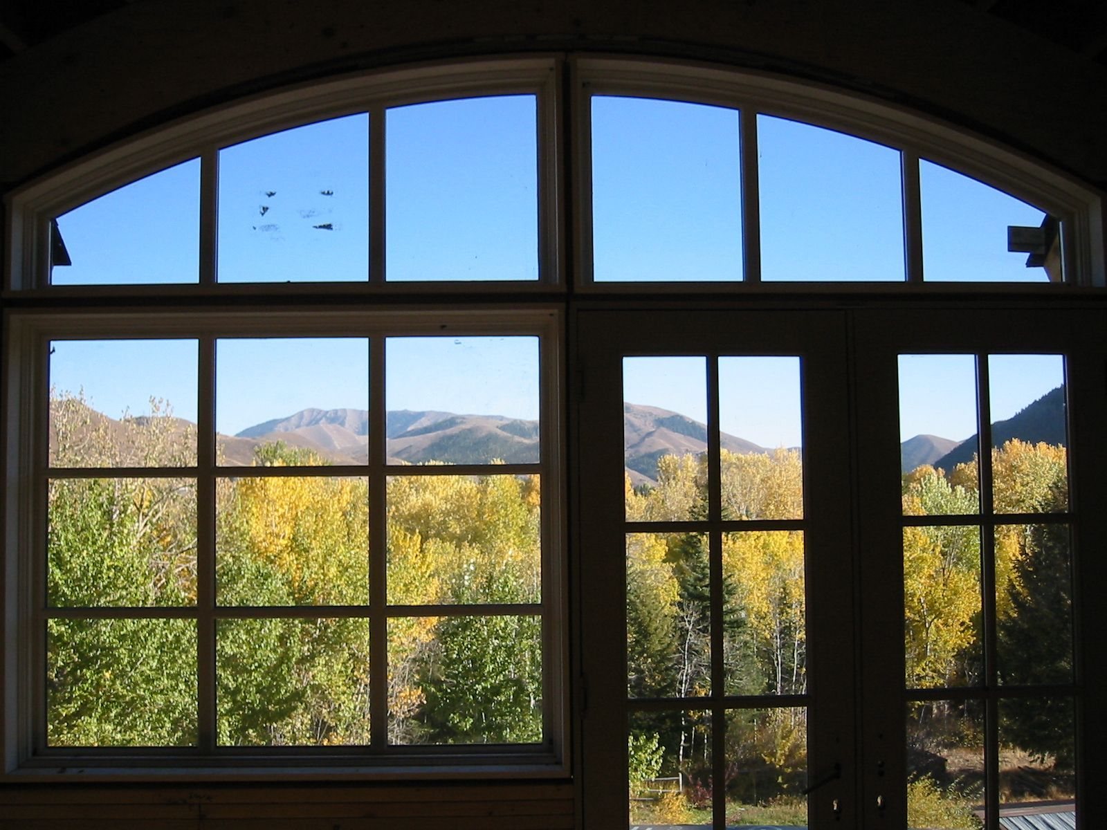 Window wall looking out to autumn aspens and mountains, Wood River Valley